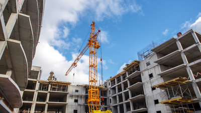 Crane construction bricks concrete building in city